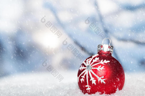 雪地上的红色圣诞球映衬着雪景。