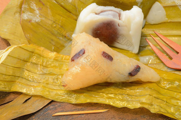 打开的<strong>泰国</strong>甜点<strong>糯米饭</strong>包裹在木质背景上的香蕉叶。