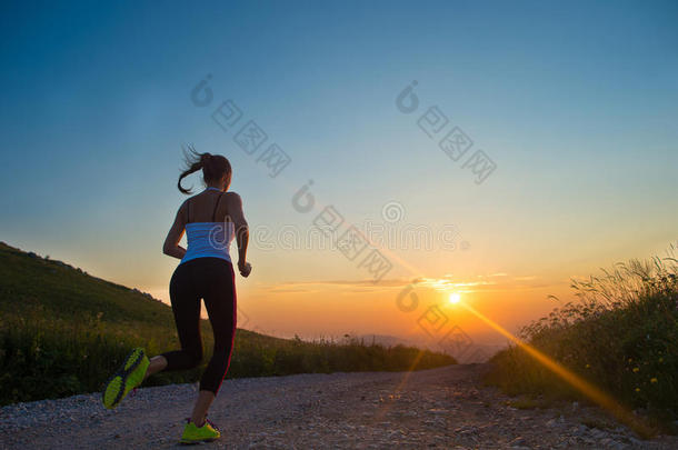 夏日夕阳下，女人在山路上奔跑