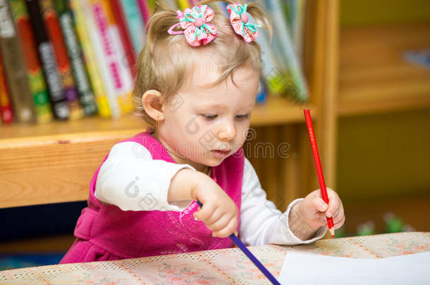 幼儿园的小女孩在饭桌上用<strong>彩色铅笔画</strong>画