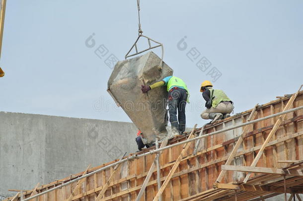 一群建筑工人在<strong>模板</strong>上浇注混凝土