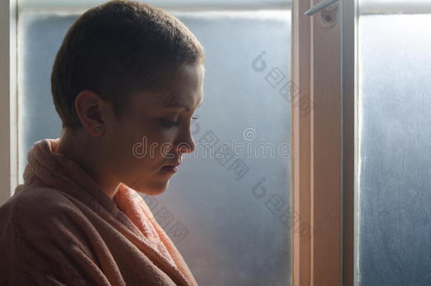站在医院橱窗前的年轻癌症病人