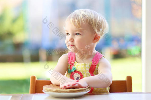 小女孩在室内玩耍吃美味的煎饼