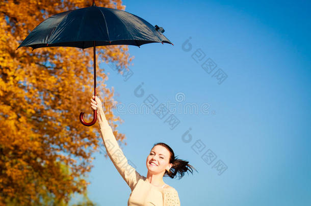 秋天公园里撑伞跳伞的女孩