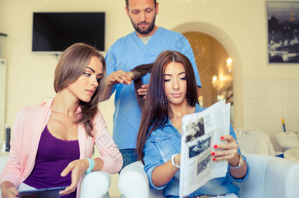 美女在平板电脑上展示发型师，例如美发沙龙的发型。