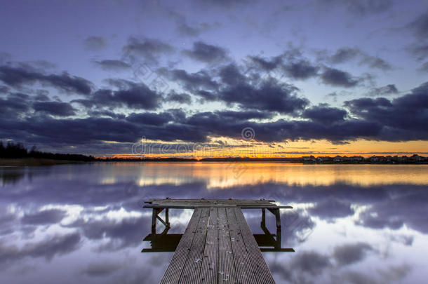 宁静的湖中，木码头上紫色的夕阳