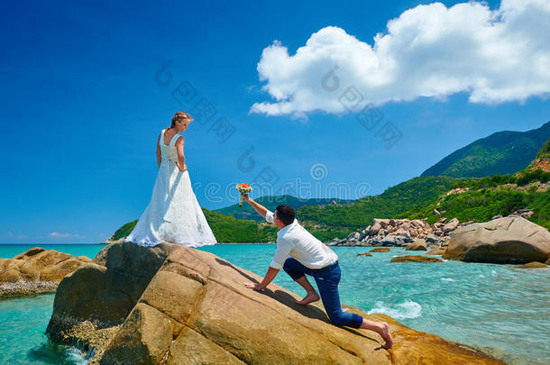 海滩上的情侣-一个男人用花束求婚