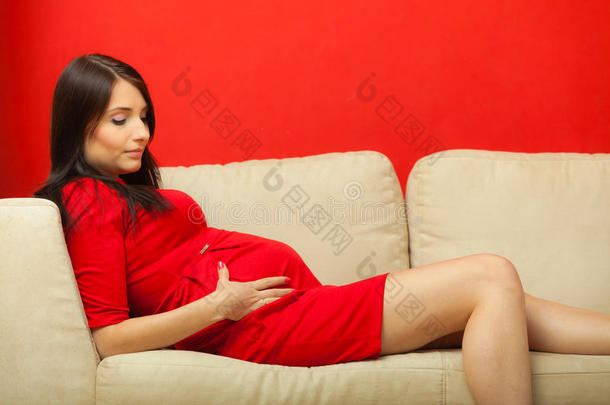 孕妇躺在沙发上抚摸肚子
