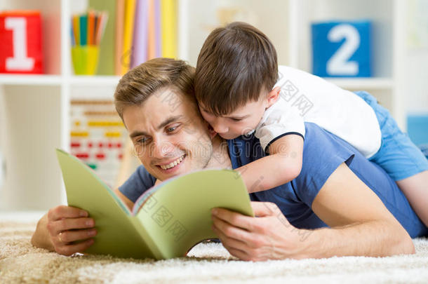 父亲和儿子在家地板上读一<strong>本书</strong>