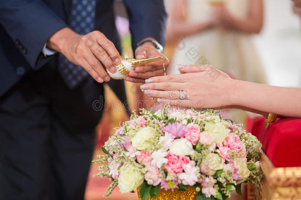 长者的手把祝福水倒在新娘的手上