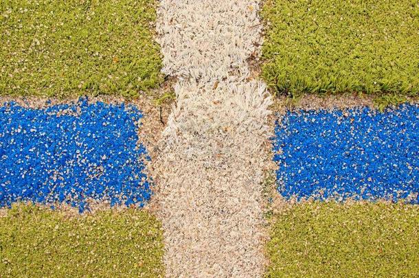 空旷的室外手球场有五颜六色的线条，地面上的塑料浅绿色表面和白色、红色和蓝色的边界线。