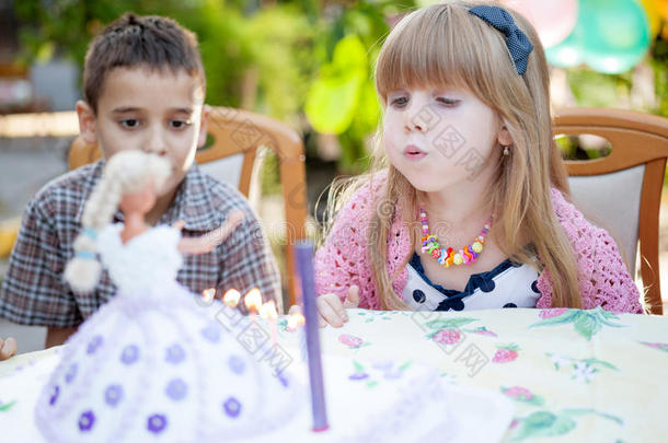 孩子们庆祝生日聚会，在蛋糕上吹蜡烛