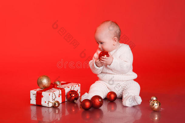 可爱的宝宝在玩圣诞礼物和装饰品
