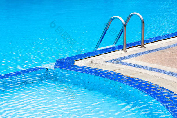 带钢梯的浅蓝色弧形游泳池。