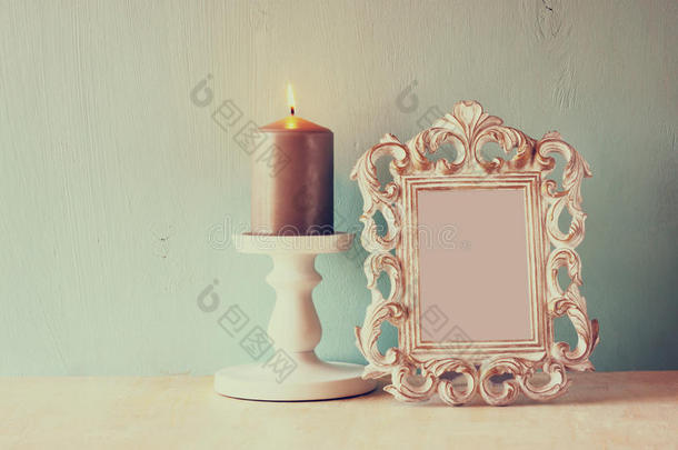 古色古香的古典画框和木桌上燃烧的蜡烛的<strong>低调</strong>形象。过滤后的图像