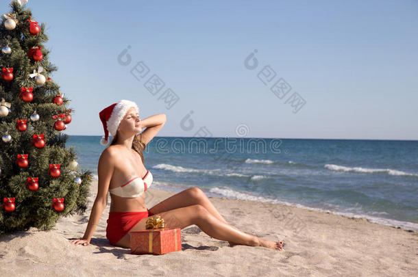 圣诞假期美丽的小女孩在海滩上晒太阳
