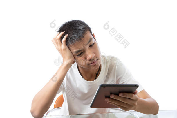 亚洲青少年使用他的平板电脑，并认真思考