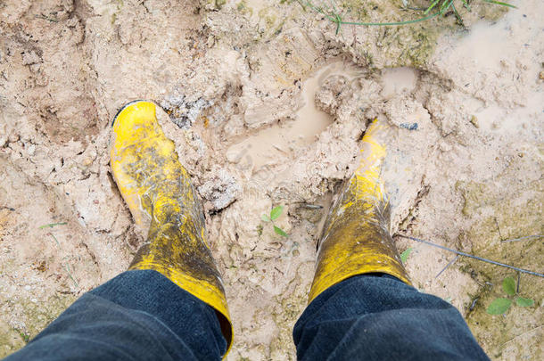 湿淤泥上的yelkow泥泞橡胶靴