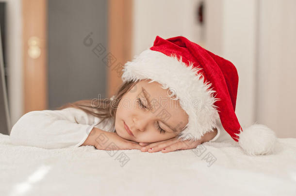 可爱的小女孩戴着圣诞帽睡觉的小女孩