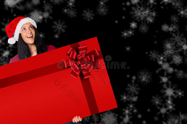 拿着一张红色圣诞<strong>丝带</strong>的<strong>卡片</strong>的女人