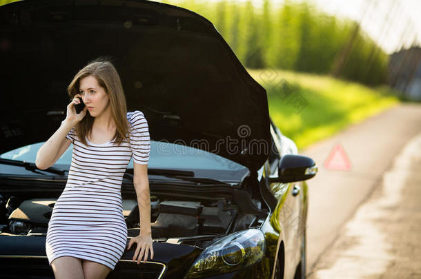 漂亮的年轻女人打电话给路边服务/救援