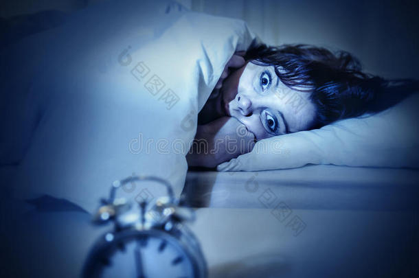 妇女在床上睁开眼睛，失眠和睡眠障碍