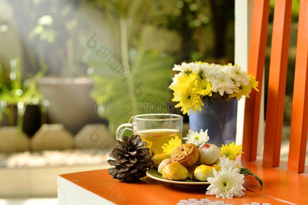 茶点、茶点和鲜花放在橙色的椅子上