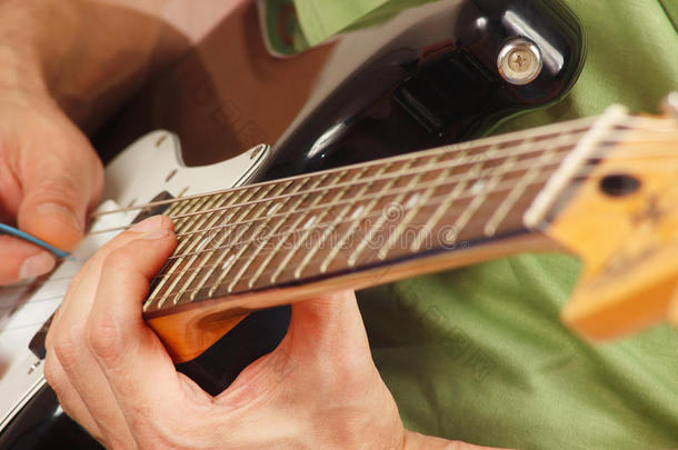 摇滚乐手把手指放在电吉他的特写上
