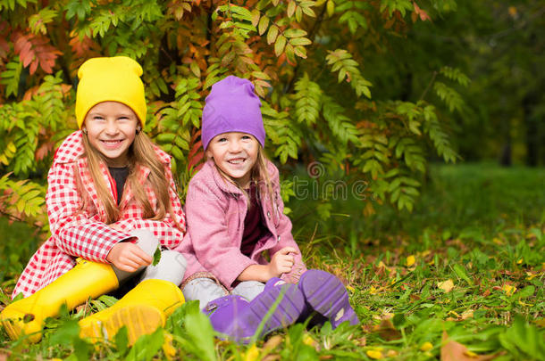 两个可爱的女孩在温暖阳光的秋天森林里