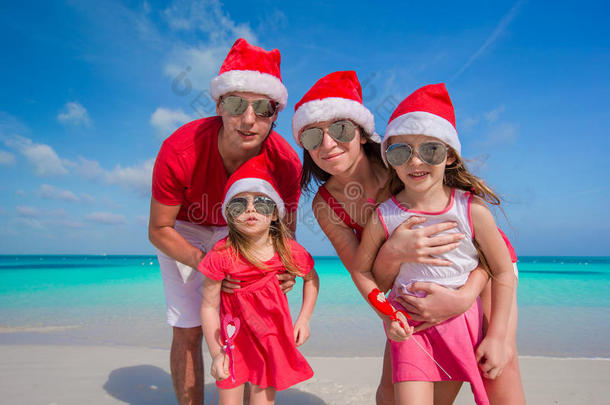 幸福的四口之家戴着白色圣诞帽