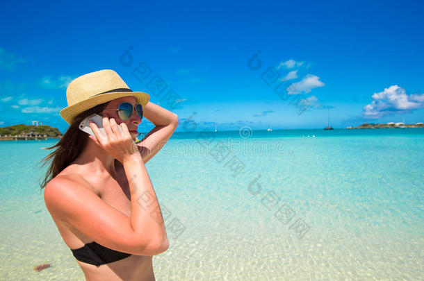 一位年轻女子在热带海滩打电话