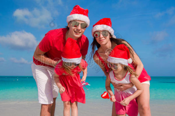 幸福的四口之家戴着白色圣诞帽