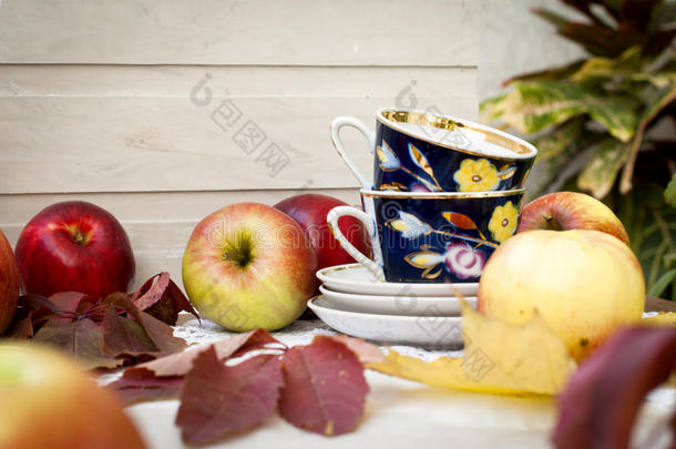 新鲜红苹果，有叶子和茶杯