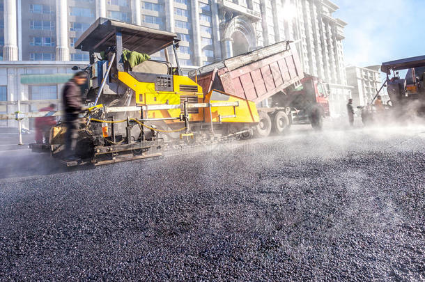 道路施工中用铲子制作沥青的工人