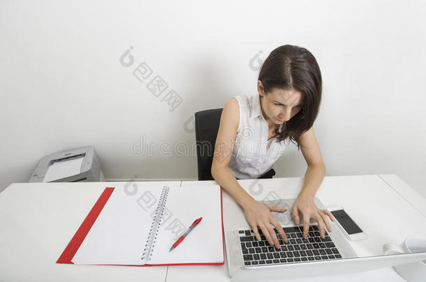 女商人在<strong>办公</strong>室<strong>办公</strong>桌上使<strong>用笔</strong>记本电脑的高角度视图