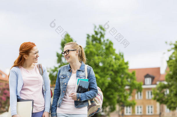 微笑的年轻女大学生朋友在户外散步