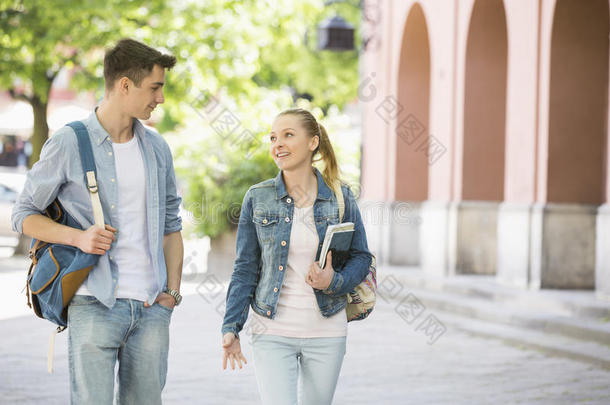 年轻的大学生朋友在校园里边走边聊天