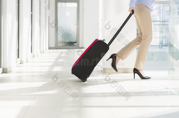 带着行李离开机场的女商人的低处