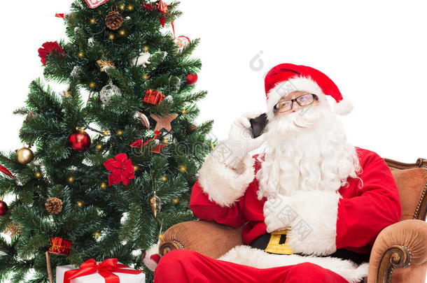 带着智能手机和圣诞树的圣诞老人