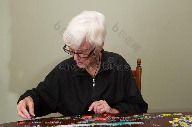 一位年长妇女拼凑的拼图游戏