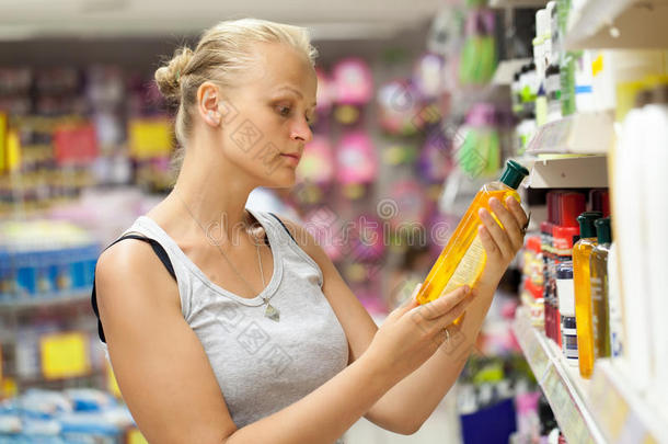 在商店里看洗发水瓶子的女人