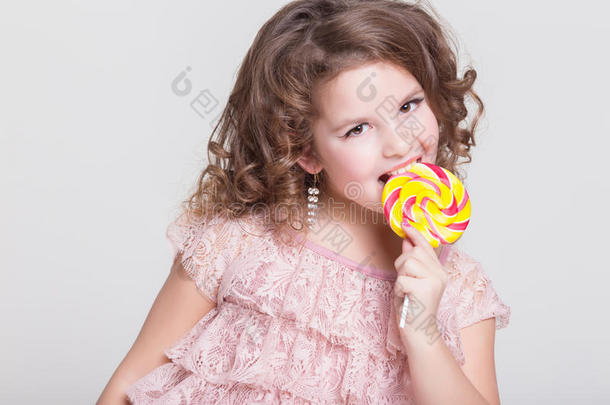 有趣的孩子吃糖果棒棒糖，小女孩吃糖果，工作室
