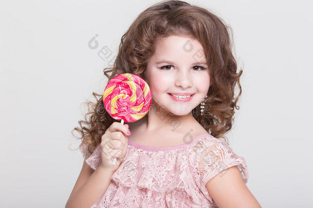 有趣的孩子吃糖果棒棒糖，小女孩吃糖果，工作室