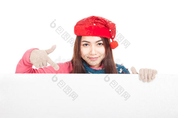 戴着红色圣诞帽的亚洲女孩指着空白的<strong>牌子</strong>