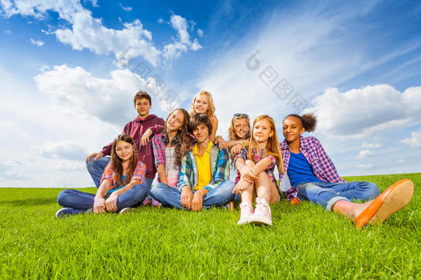 快乐的<strong>国际儿童</strong>坐在绿色的草地上