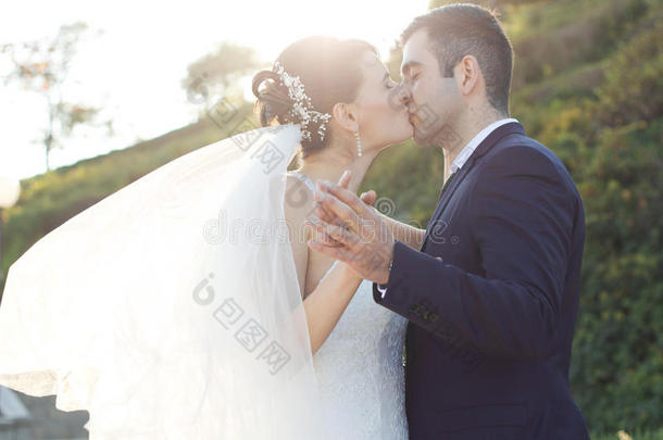 浪漫的年轻新婚夫妇在花园里接吻