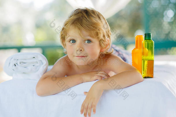 可爱的金发小男孩在水疗中心享受按摩