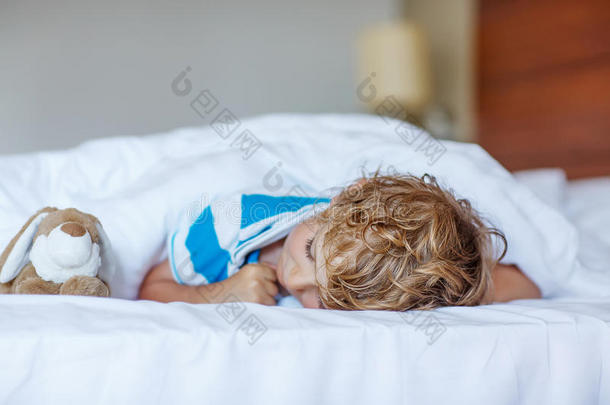 可爱的孩子和玩具在他的白色床上睡觉和做梦