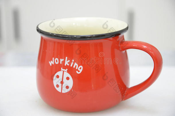 <strong>红色</strong>咖啡杯放在桌子上，白底