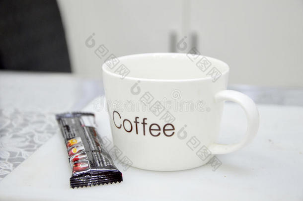 一个白色的咖啡杯放在桌子上和白色的背景上